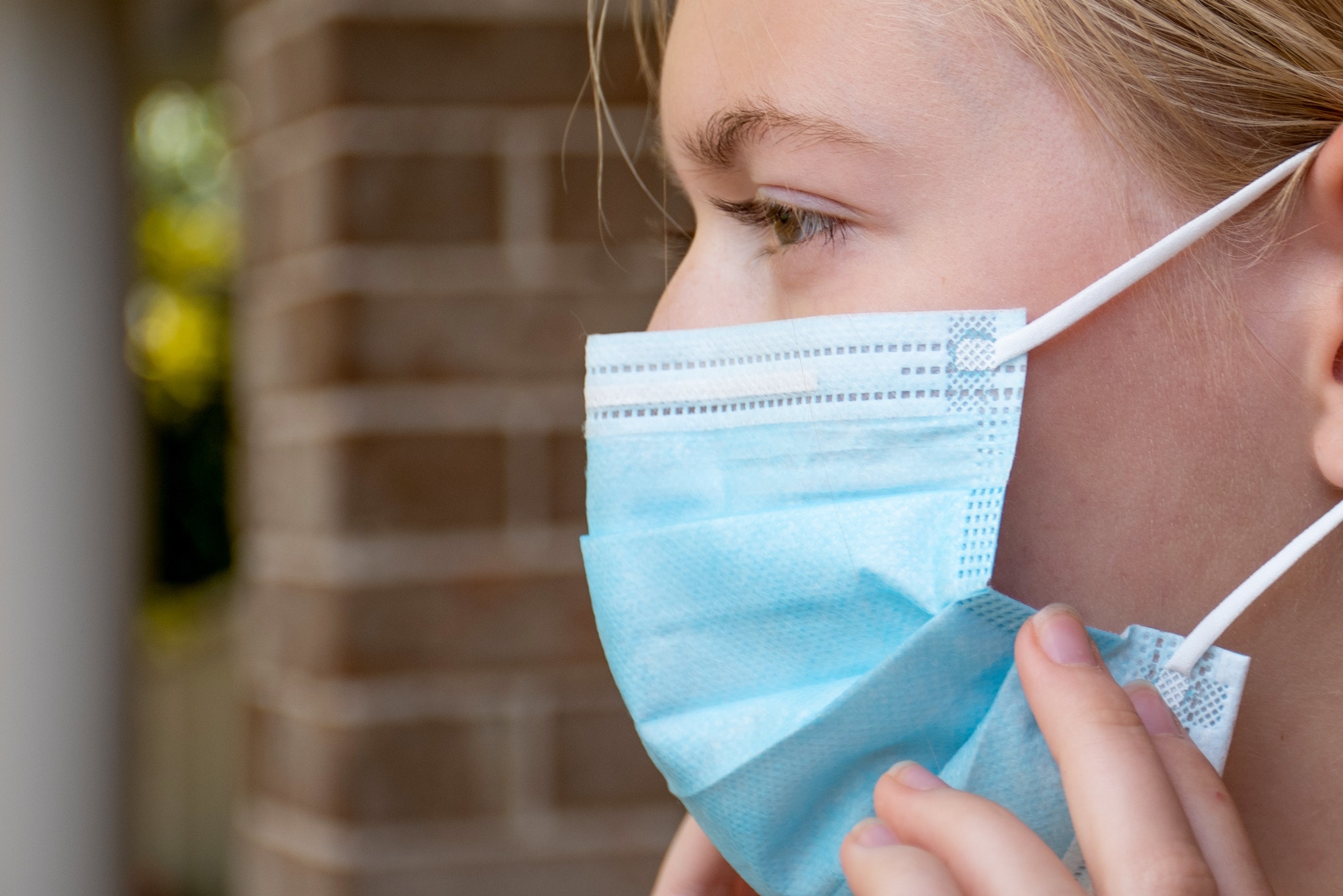 A girl wearing disposable face mask. Compulsory mandatory masks. Coronavirus COVID-19 Concept