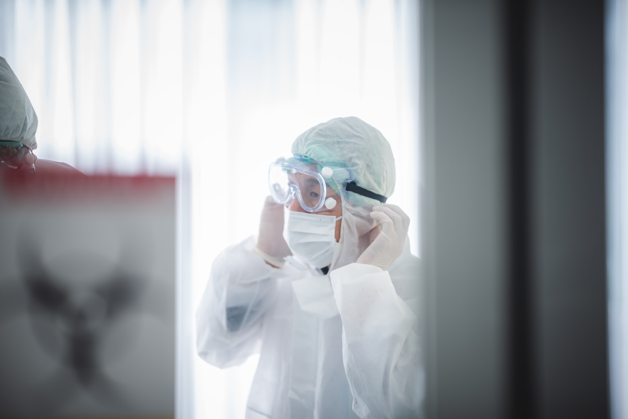 professional doctors in the full protective suits and surgical masks are examining