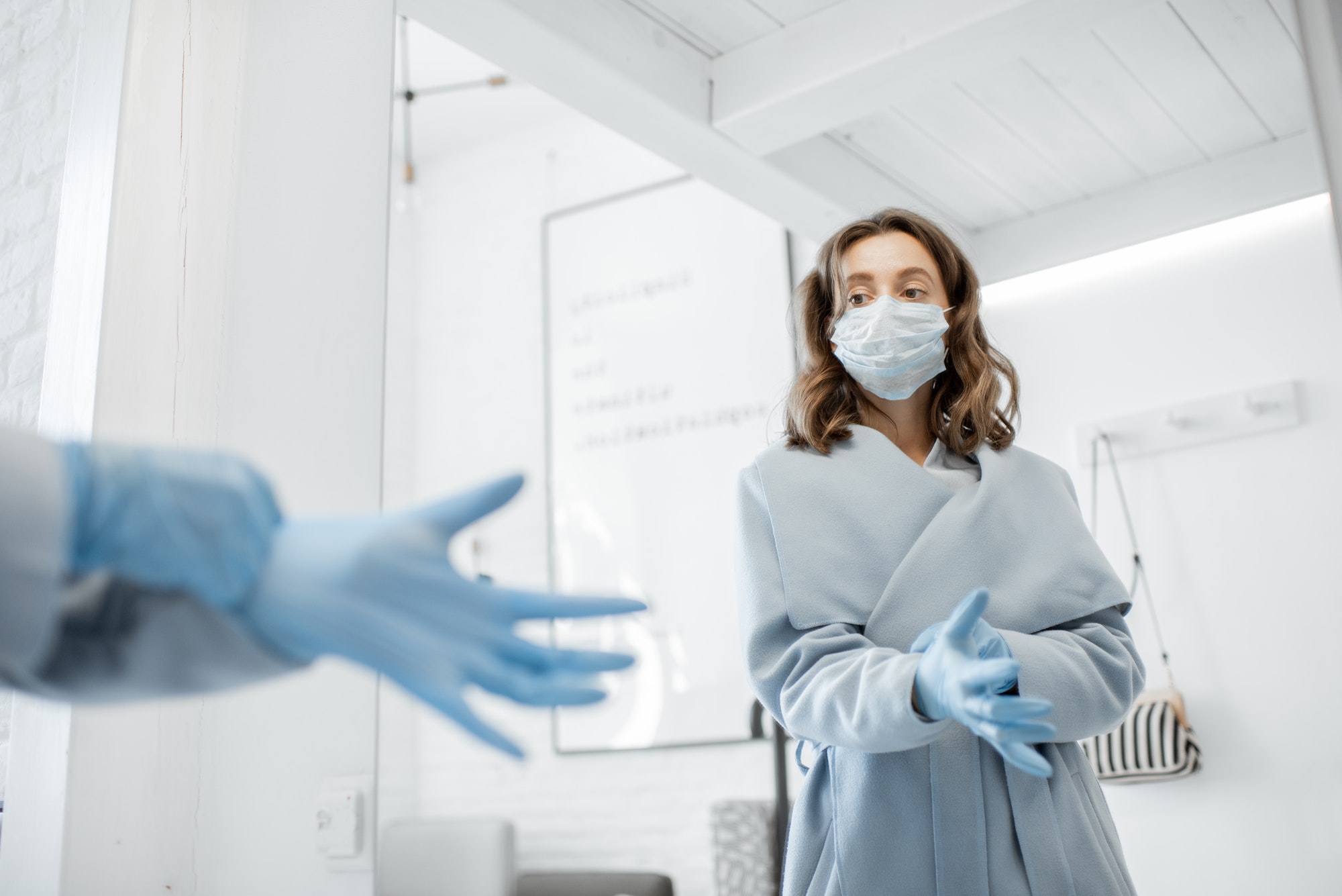 Woman in medical mask wearing gloves while going outside